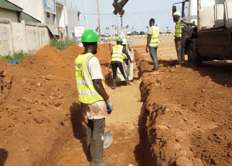 Pose de caniveaux en béton armé pour drainage sur la route Yakassé Attobrou - Biéby - Bettie, projet Hoshi BTP.